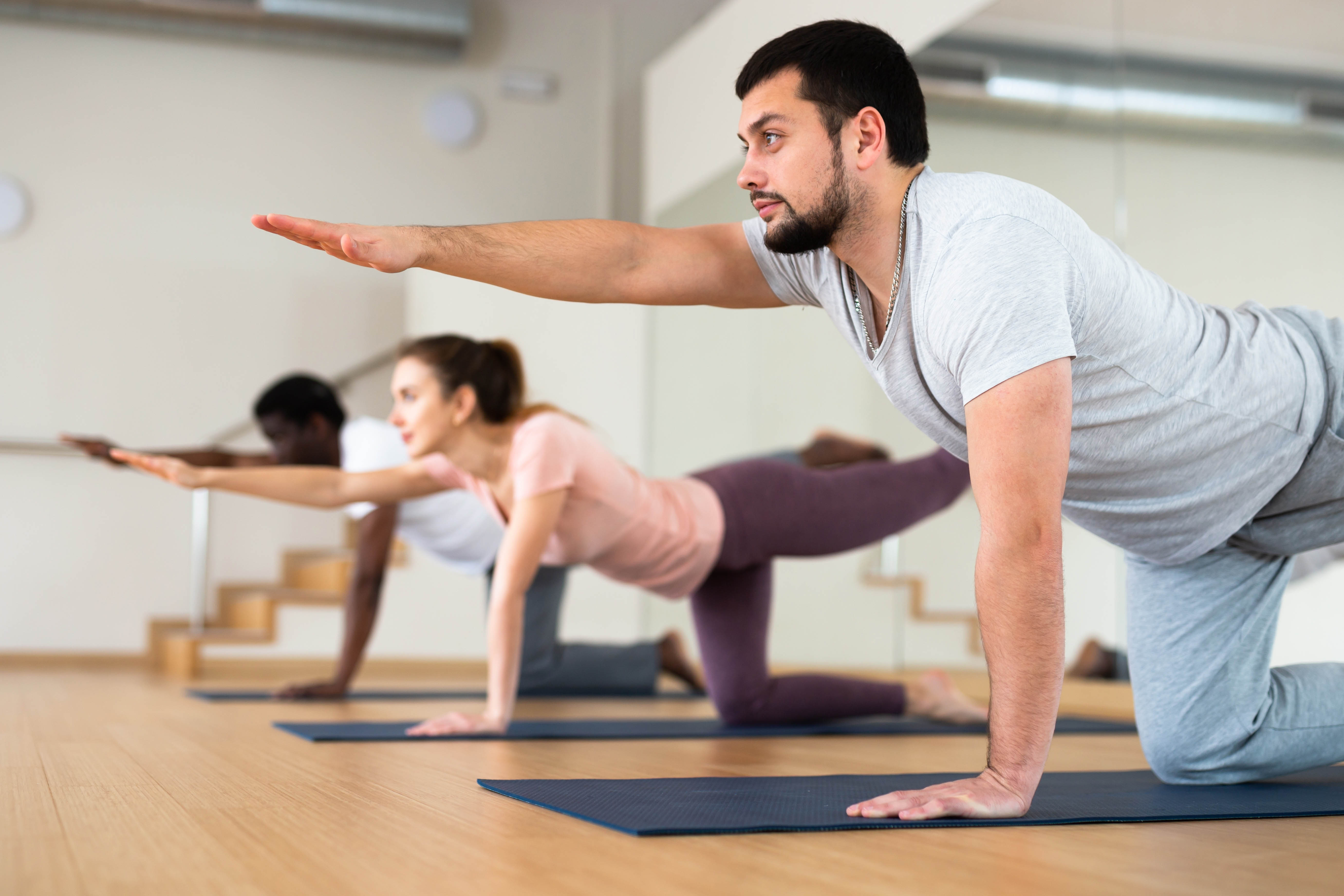 Man and woman stretching in a group yoga workout class